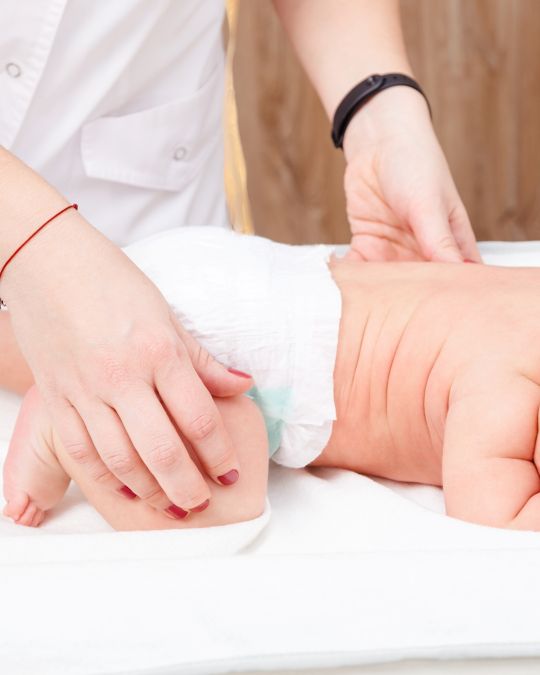 Lekarz badający bioderka noworodka - ilustracja dotycząca USG preluksjacyjnego bioderek u dzieci w Centrum Medycznym neoMedica w Poznaniu.