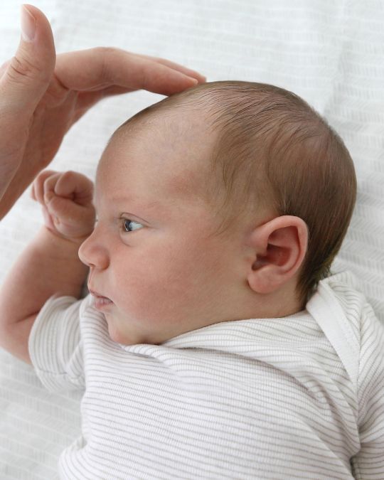 Lekarz badający główkę dziecka - ilustracja dotycząca USG przezciemiączkowego głowy dziecka w Centrum Medycznym neoMedica w Poznaniu.